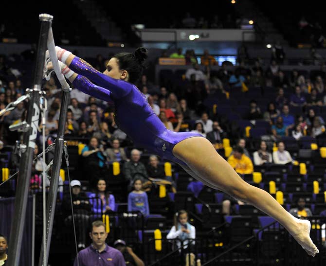 LSU junior all-around Rheagan Courville leaps toward the uneven bars Friday, Jan. 10, 2014 during the Tigers' 197.200-181.275 win against Centenary in the PMAC.