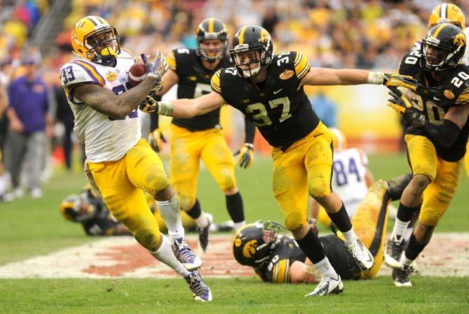 LSU sophomore running back Jeremy Hill (33) attempts to evade an Iowa defender Wednesday, January 1, 2014 during the Tigers' 21-14 victory against the Hawkeyes in the Outback Bowl at Raymond James Stadium in Tampa, Florida.