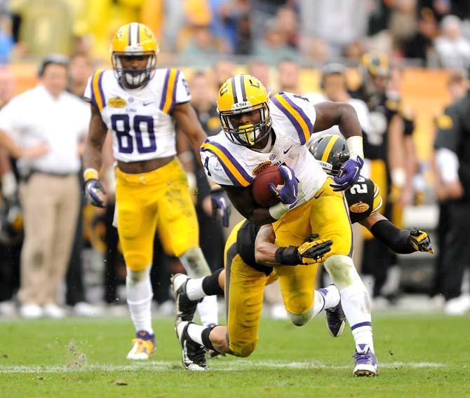 LSU senior running back Alfred Blue (4) attempts to shake off an Iowa defender Wednesday, January 1, 2014 during the Tigers' 21-14 victory against the Hawkeyes in the Outback Bowl at Raymond James Stadium in Tampa, Florida.