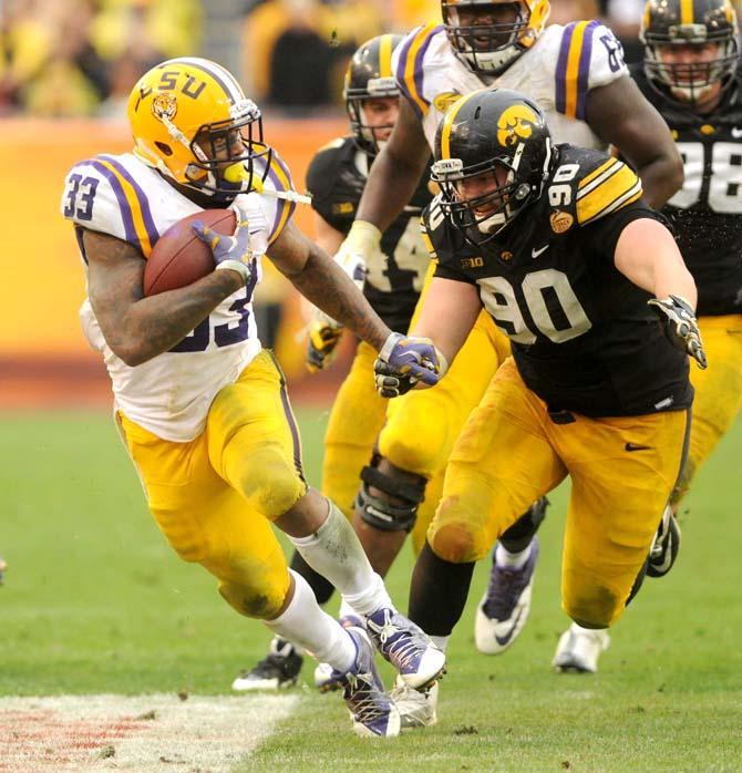 LSU sophomore running back Jeremy Hill (33) attempts to evade an Iowa defender Wednesday, January 1, 2014 during the Tigers' 21-14 victory against the Hawkeyes in the Outback Bowl at Raymond James Stadium in Tampa, Florida.