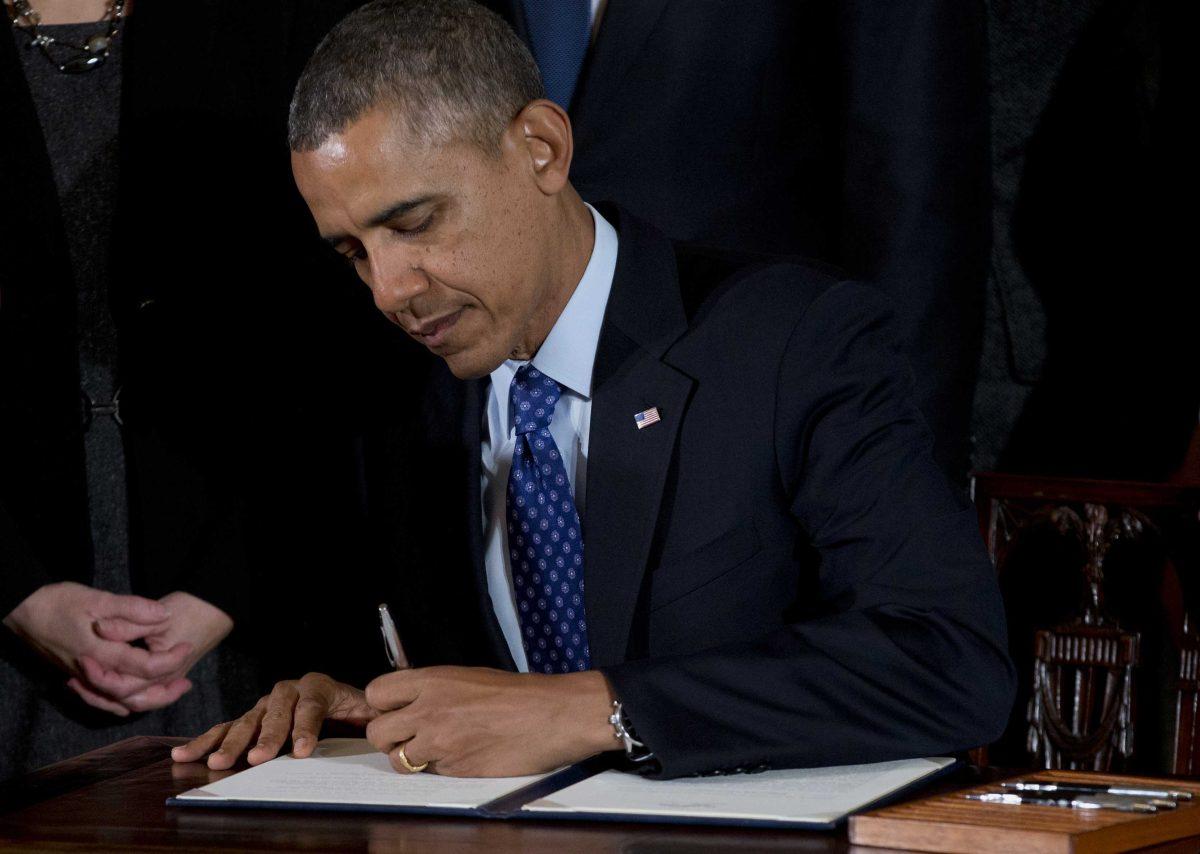 President Barack Obama signs a memorandum creating a task force to respond to campus rapes during an event for the Council on Women and Girls, Wednesday, Jan. 22, 2014, in the East Room of the White House in Washington. (AP Photo/Carolyn Kaster)