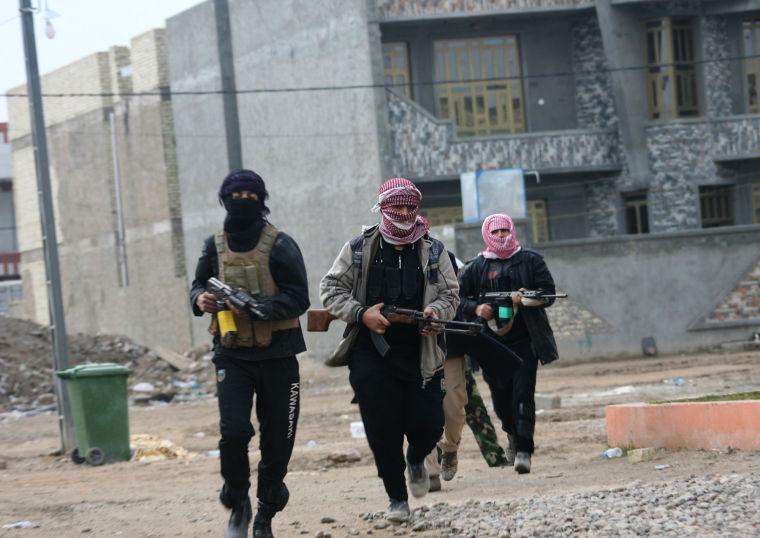 FILE - In this January 5, 2014, file photo, gunmen patrol during clashes with Iraqi security forces in Fallujah, 40 miles (65 kilometers) west of Baghdad, Iraq. With a new label - the Islamic State of Iraq and the Levant - the global terror network al-Qaida is positioning itself as a vanguard defending a persecuted Sunni community against Shiite-dominated governments across Syria, Lebanon and Iraq. The al-Qaida gains pose the most serious challenge to Prime Minister Nouri al-Maliki's Shiite-led government since the departure of American forces in late 2011. (AP Photo, File)