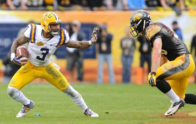 LSU junior wide receiver Odell Beckham Jr. (3) attempts to ward off an Iowa defender Wednesday, January 1, 2014 during the Tigers' 21-14 victory against the Hawkeyes in the Outback Bowl at Raymond James Stadium in Tampa, Florida.