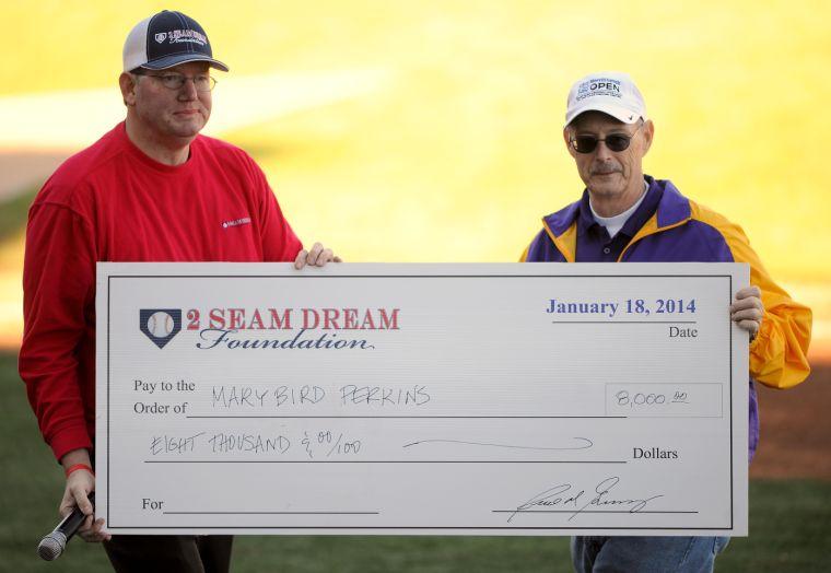 Cancer Awareness Day event coordinator Rick Green presents a check from the 2 Seam Dream Foundation for eight thousand dollars to a representative of Mary Bird Perkins Cancer Center on Saturday, January 18, 2014 at the Alex Box Stadium, Skip Bertman Field.