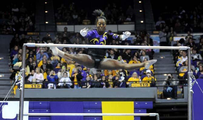 LSU junior all-around gymnast Britney Ranzy reaches for a bar during her uneven bar routine Friday, Jan. 31, 2014 during the Tigers' 197.650-196.825 victory against Alabama in the PMAC.