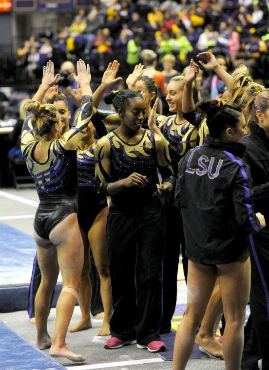 The LSU Gymnist team hi-fives after a high-scoring routine was performed by one of the members.