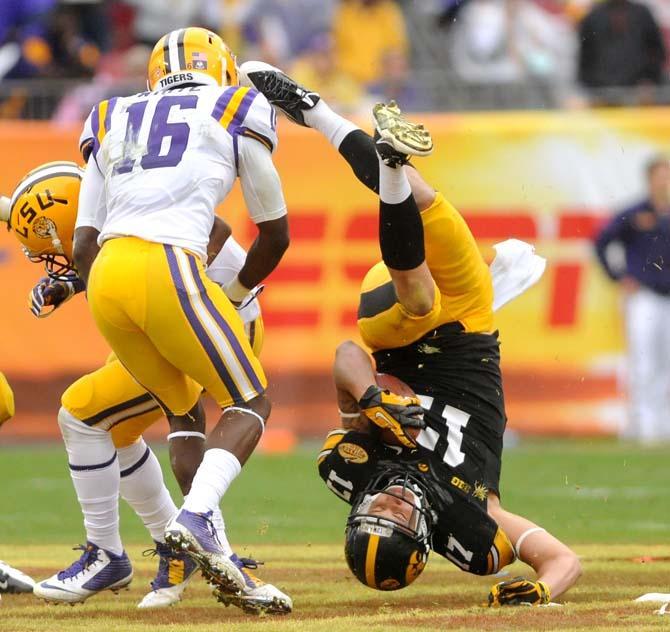 Iowa sophomore wide receiver Jacob Hillyer (17) rolls to the ground Wednesday, January 1, 2014 after being tackled by LSU freshman defensive back Tre'Davious White (16) during the Tigers' 21-14 victory against the Hawkeyes in the Outback Bowl at Raymond James Stadium in Tampa, Florida.