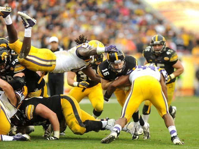 LSU senior linebacker Lamin Barrow (18) leaps to tackle Iowa freshman quarterback C.J. Beathard (16) Wednesday, January 1, 2014 during the Tigers' 21-14 victory against the Hawkeyes in the Outback Bowl at Raymond James Stadium in Tampa, Florida.