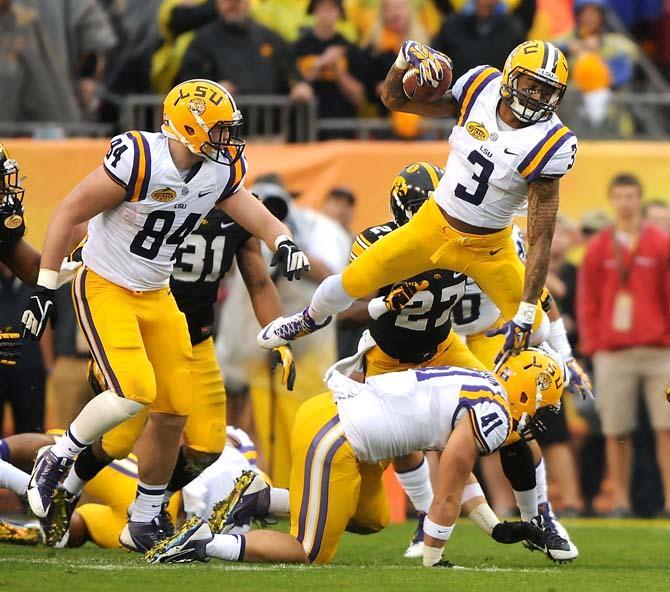 LSU junior wide receiver Odell Beckham Jr. (3) leaps over teammate junior tight end Travis Dickson (41) January 1, 2014 during the Tigers' matchup against Iowa in the 2104 Outback Bowl in Raymond James Stadium. The Tigers lead the Hawkeyes 14-0 at halftime.