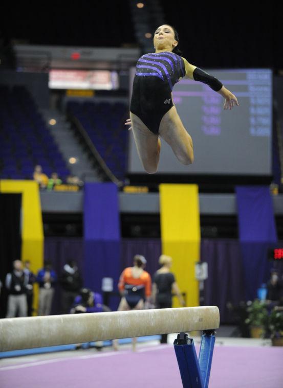 LSU Gymnist, Rheagan Courville, performing jumping high into the air during her balance beam routine at the LSU vs Auburn Gym Meet at the PMAC on 1.25.14.