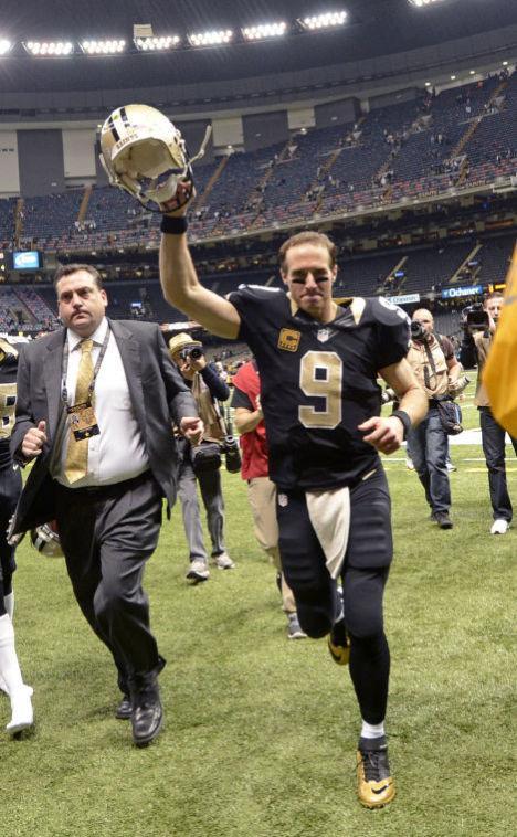 New Orleans Saints quarterback Drew Brees (9) acknowledges the fans as he runs off the field after an NFL football game against the Tampa Bay Buccaneers in New Orleans, Sunday, Dec. 29, 2013. The Saints won 42-17. (AP Photo/Bill Feig)