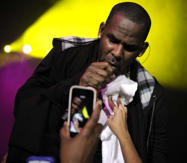 A woman wipes the sweat from R. Kelly's face during his performance Thursday night, February 13, 2014 downtown at the Baton Rouge River Center.