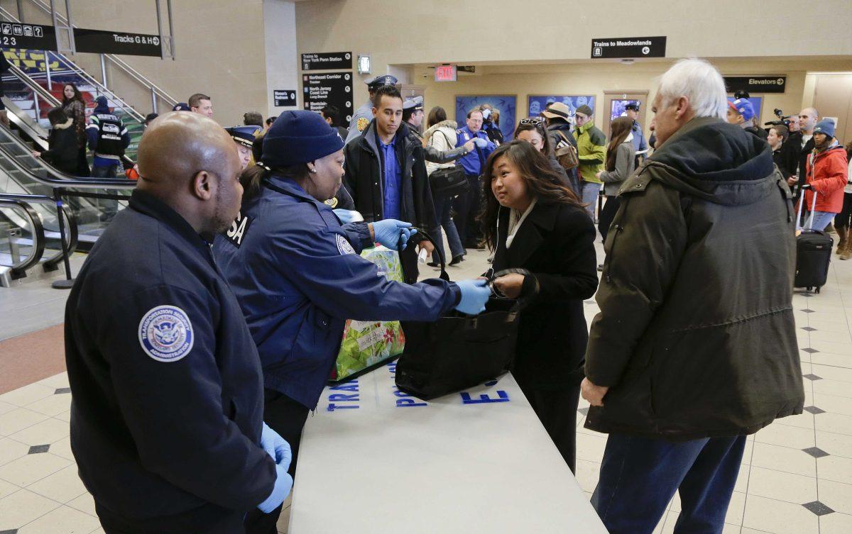 Transportation Security Administration officers prepare to screen a passenger's bag at the Secaucus Junction Station, Friday, Jan. 31, 2014, in Secaucus, N.J. The TSA and New Jersey Transit Police began searching bags at the Station Friday in preparation for Sunday's Super Bowl at the Meadowlands. All passengers will be screened by TSA officers before they will be allowed to board trains to Met Life Stadium on Sunday.(AP Photo/Julie Jacobson)