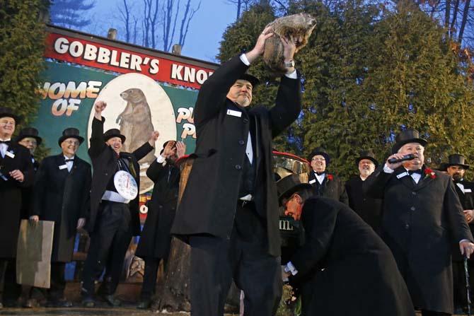 Punxsutawney Phil is held by handler John Griffiths after emerging from his burrow Sunday, Feb. 2, 2014, on Gobblers Knob in Punxsutawney, Pa., to see his shadow and forecast six more weeks of winter weather. This year's Groundhog Day celebration marks a winter that has brought extreme cold to stretches of the United States wholly unaccustomed to it, as well as a snow and ice storm that paralyzed Atlanta and other Southern cities. (AP Photo/Gene J. Puskar)