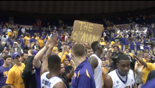 LSU player celebrate with students after a victory over Arkansas.