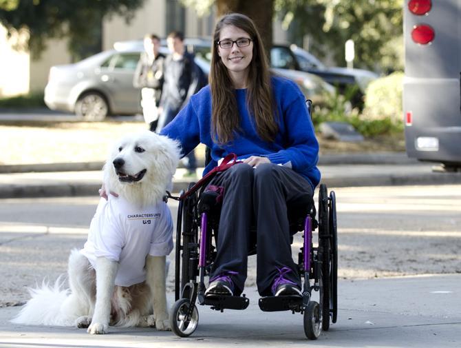 LSU Junior Alexandria Arceneaux, a food science major, next to Mishka, her guide dog, while wearing his "I Won't Stand For..." t-shirt stamped with "Ableism".