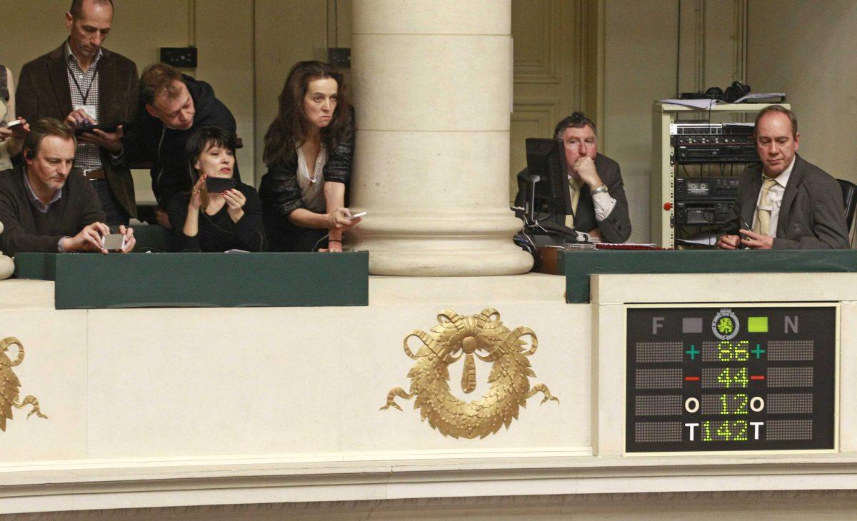 Journalists look at the electronic voting board as Belgian politicians vote in favour of the bill on child euthanasia at the Belgian federal parliament in Brussels, Thursday Feb. 13, 2014. Belgium, one of the very few countries where euthanasia is legal, takes the unprecedented step of abolishing age restrictions on who can ask to be put to death, extending the right to children. The legislation appears to have wide support in the largely liberal country. But it has also aroused intense opposition from foes, including a list of pediatricians, and everyday people who have staged street protests, fearing that vulnerable children will be talked into making a final, irreversible choice. (AP Photo/Yves Logghe)