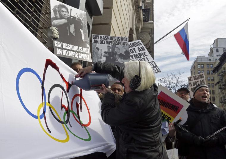 Activist Ann Northrop is joined by demonstrators from Queer Nation, and others who oppose the Russian government&#8217;s continued attacks on human rights, including the rights of LGBT Russians, as she pours fake blood on an Olympic flag, marking the start of the 2014 Winter Olympic Games with a protest, outside the Consulate General of the Russian Federation, in New York, Thursday, Feb. 6, 2014. (AP Photo/Richard Drew)