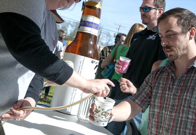 A brewer pours beer from a tap for a patron Saturday, Feb. 15, 2014 during the 2014 Brasseurs a la Maison Iron Brewer Festival at Tin Roof Brewing Company in Baton Rouge.