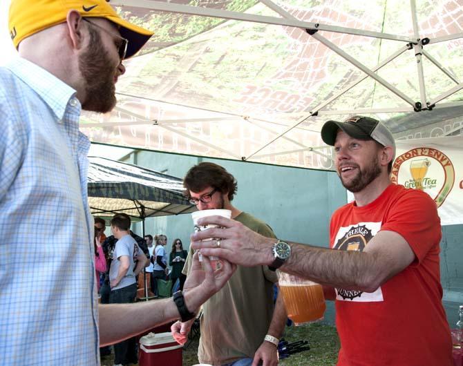 A brewer hands a beer to a patron Saturday, Feb. 15, 2014 during the 2014 Brasseurs a la Maison Iron Brewer Festival at Tin Roof Brewing Company in Baton Rouge.