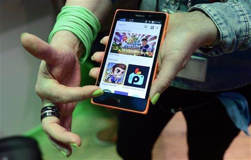 A woman shows the new Nokia XL at the Mobile World Congress, the world's largest mobile phone trade show in Barcelona, Spain, Wednesday, Feb. 26, 2014. The global wireless show that wraps up on Thursday has seen a push to get mobile devices cheap enough to reach emerging markets without sacrificing so much performance. While the affluent crave the latest iPhones or Android phones, most of the world can't afford the hundreds of dollars they cost. (AP Photo/Manu Fernandez)