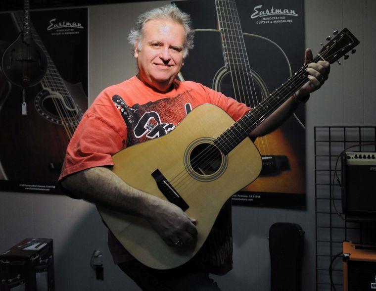 Tim Lawson plays his favorite guitar at the shop Friday afternoon, Feb. 7, 2014 at Tim's Guitar Repair and Workshop.