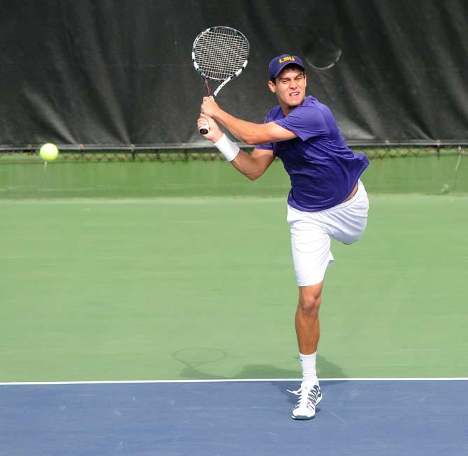 LSU freshman Eric Perez hits a volley Saturday, Feb. 8, 2013 during the Tigers' doubles match at W.T. "Dub" Robinson Stadium.