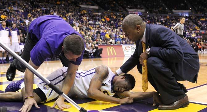 LSU head beasketball coach Johnny Jones checks on sophomore guard Malik Morgan (24) after Morgan injusted his knee Saturday, Feb. 8, 2013 during the Tigers' 87-80 victory against the Auburn Tigers in the PMAC.