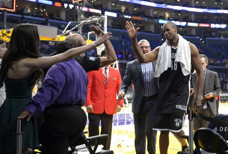 Brooklyn Nets center Jason Collins, right, is congratulated by fans after they defeated the Los Angeles Lakers in an NBA basketball game, Sunday, Feb. 23, 2014, in Los Angeles. Brooklyn won 108-102. (AP Photo/Mark J. Terrill)