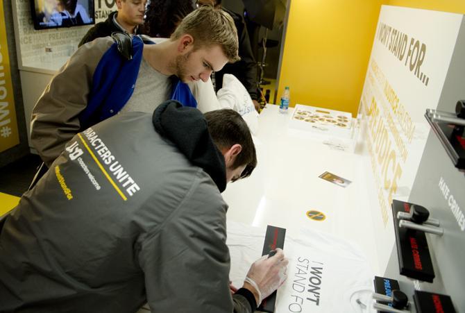 James Miller, from New Orleans, Louisiana, works on the USA Characters Unite campaign staff and helps an LSU student stamp a shirt with "Discriminatin".