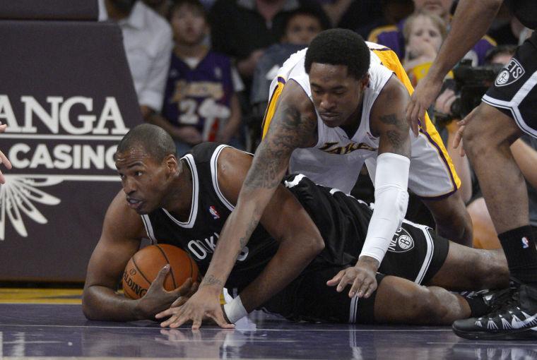 Brooklyn Nets center Jason Collins, left, battles for a loose ball with Los Angeles Lakers guard MarShon Brooks during the first half of an NBA basketball game, Sunday, Feb. 23, 2014, in Los Angeles. (AP Photo/Mark J. Terrill)