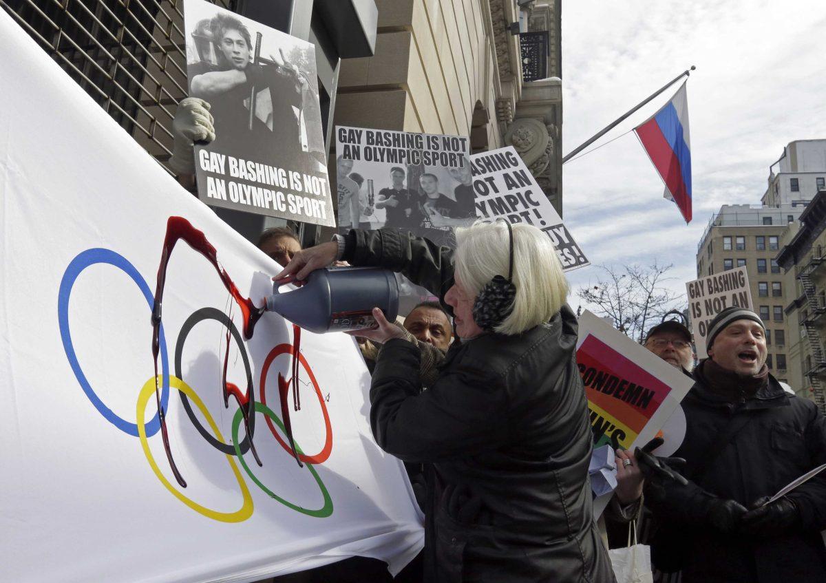 Activist Ann Northrop is joined by demonstrators from Queer Nation, and others who oppose the Russian government&#8217;s continued attacks on human rights, including the rights of LGBT Russians, as she pours fake blood on an Olympic flag, marking the start of the 2014 Winter Olympic Games with a protest, outside the Consulate General of the Russian Federation, in New York, Thursday, Feb. 6, 2014. (AP Photo/Richard Drew)