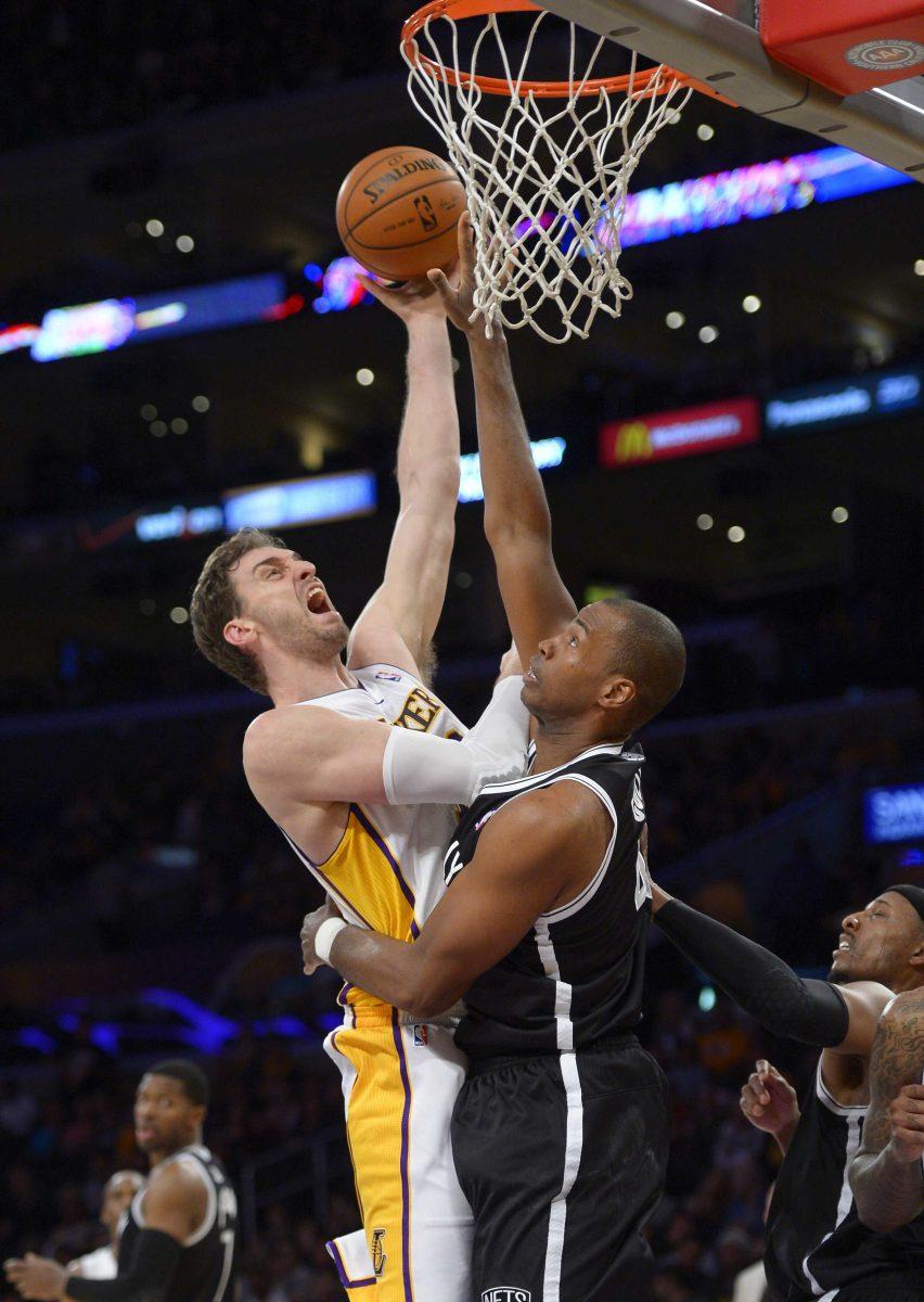 Los Angeles Lakers center Pau Gasol, left, of Spain, puts up a shot as Brooklyn Nets center Jason Collins defends during the second half of an NBA basketball game, Sunday, Feb. 23, 2014, in Los Angeles. The Nets won 108-102. (AP Photo/Mark J. Terrill)