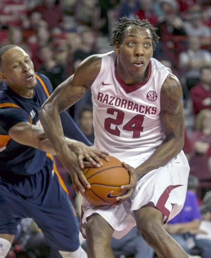 FILE - In this Dec. 19, 2013, filephoto, Arkansas' Michael Qualls (24) looks to the basket as Tennessee-Martin's Terence Smith attempts a steal during the second half of an NCAA college basketball game in Fayetteville, Ark. Qualls led Arkansas in its nonconference schedule but has struggled in Southeastern Conference play. (AP Photo/Gareth Patterson, File)