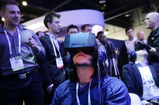 FILE - In this Jan. 7, 2014 file photo, show attendees play a video game wearing Oculus Rift virtual reality headsets at the Intel booth at the International Consumer Electronics Show(CES), in Las Vegas. Facebook said Tuesday, March 25, 2014, it has agreed to buy Oculus for $2 billion, betting that its virtual reality may be a new way for people to communicate, learn or be entertained. (AP Photo/Jae C. Hong, File)