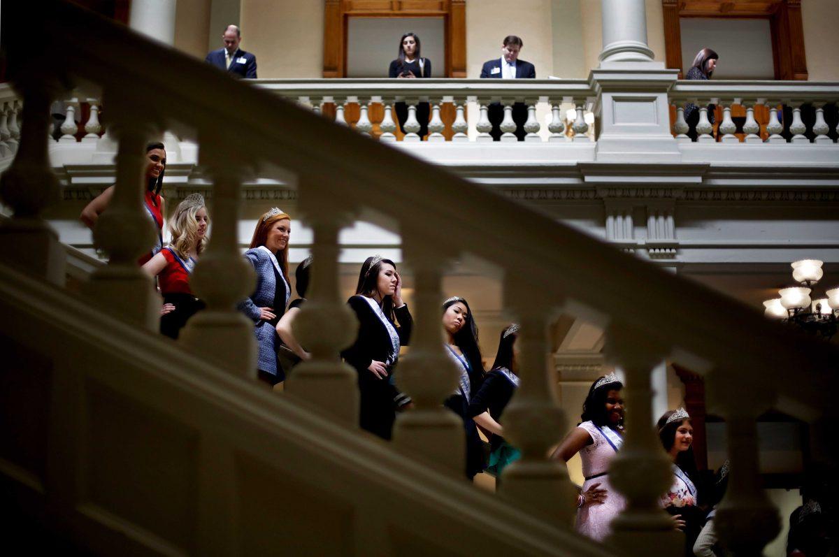 Miss Dacula Pageant representatives from Dacula, Ga., stand on the steps inside the Statehouse while posing for photos during a visit, Wednesday, March 5, 2014, in Atlanta. (AP Photo/David Goldman)