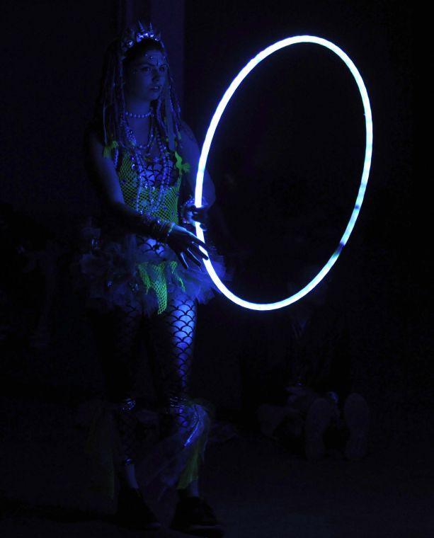 The glow of a hula hoop illuminates a festival-goer during Buku Music + Art Project on Friday, March 21, 2014 at Mardi Gras World in New Orleans.