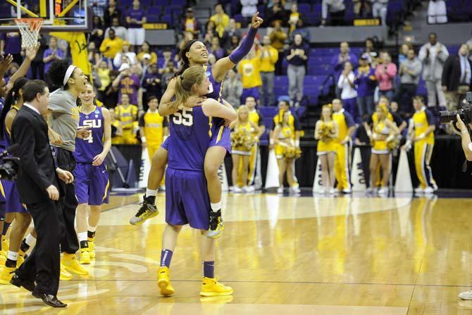 LSU senior forward Theresa Plaisance (55) hoists sophomore guard Danielle Ballard (32) in the air Tuesday, March 25, 2014, following the Tigers' 76-67 win against West Virginia in the PMAC.