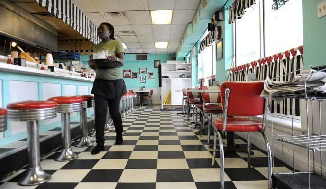 Waitress Jessica Poni carries drinks to a table Sunday, March 23, 2014 at Louie's Café.