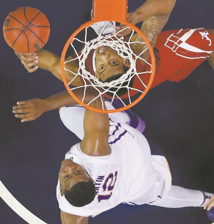 Alabamam forward Shannon Hale (11) and LSU forward Jarell Martin (12) watch a loose ball Thursday during the Tigers' 68-56 victory against Alabama in the second round of the Southeastern Conference men's tournament.&#160;