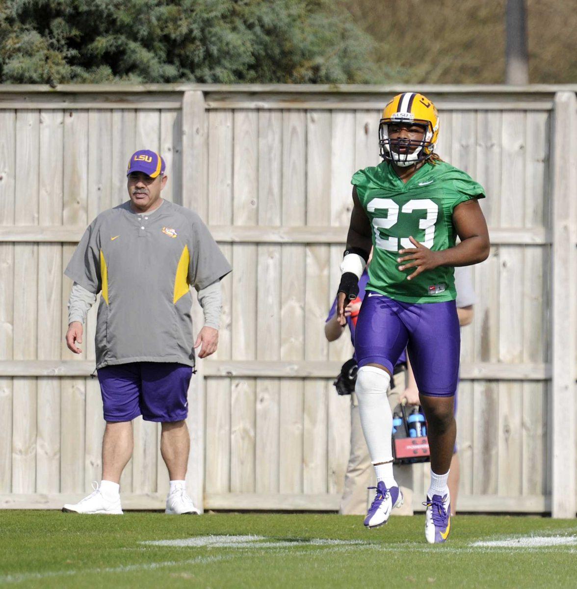 LSU defensive coordinator John Chavis (left) watches junior linebacker Lamar Louis (23) on Monday, March 10, 2014 during practice at the Charles McClendon Practice Facility.