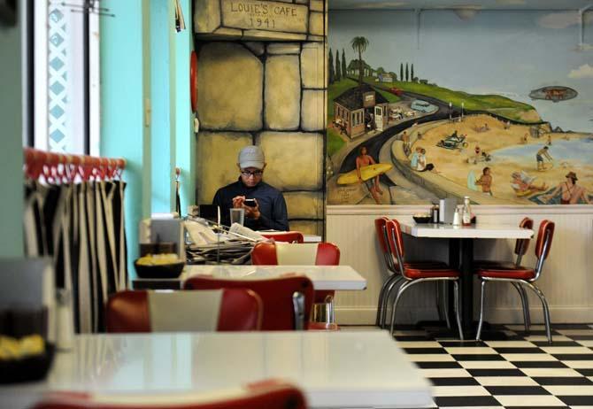 A customer sits at a table Sunday, March 23, 2014 at Louie's Café.