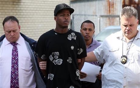 Shawn Scott, center, who with his younger brother Akien is accused of the Mother's Day second-line shooting which injured 20 people, is taken from the 5th District Police Station to Orleans Parish Prison in New Orleans on Thursday, May 16, 2013. The Times-Picayune.