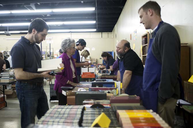 Shoppers look at books displayed on a table at the LSU Libraries Friends of the Libraries Annual Book Bazaar on Thursday, March 20, 2014 in the 4-H mini barn.