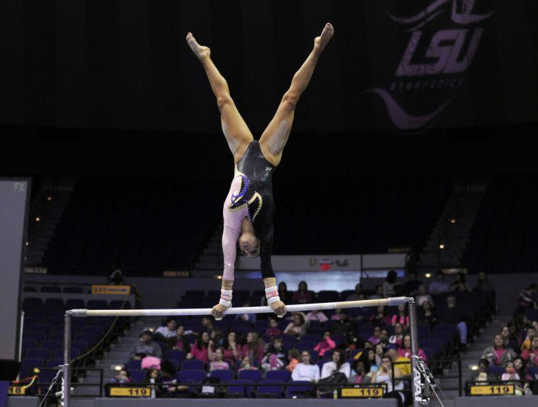 All-around gymnast Rheagan Courville warms up on the uneven bars Friday, March 7, 2014 during the Tigers' 197.500 - 195.525 victory against NC State in the Pete Maravich Assembly Center.