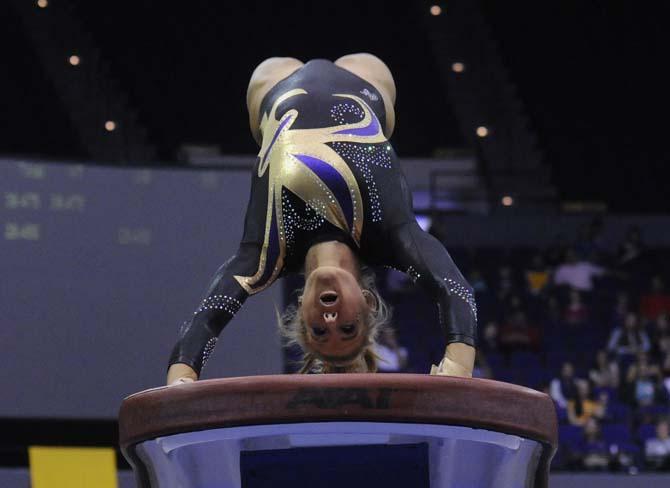 LSU senior Sarie Morrison attempts a vault Friday, March 14, 2014 during the Lady Tigers' 197.800-195.000 victory against Kentucky in the PMAC.