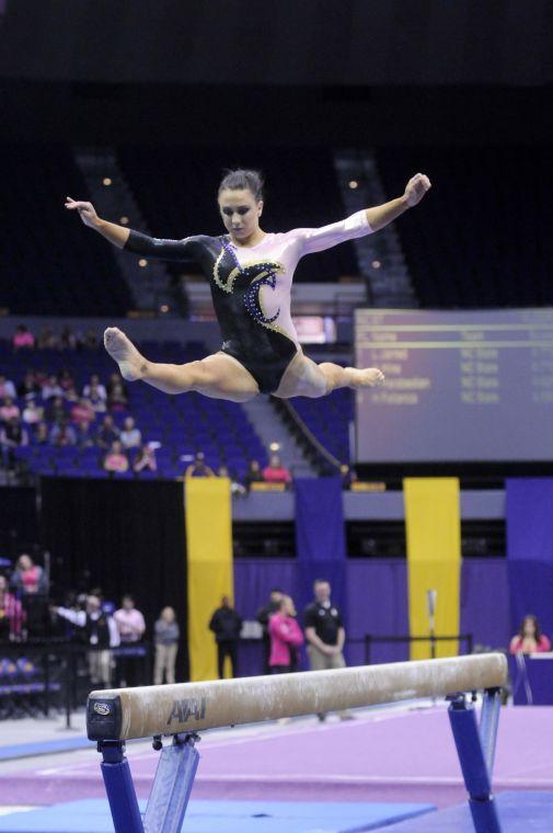 All-around gymnast Rheagan Courville leaps off the beam Friday, March 7, 2014 during the Tigers' 197.500 - 195.525 victory against NC State in the Pete Maravich Assembly Center.