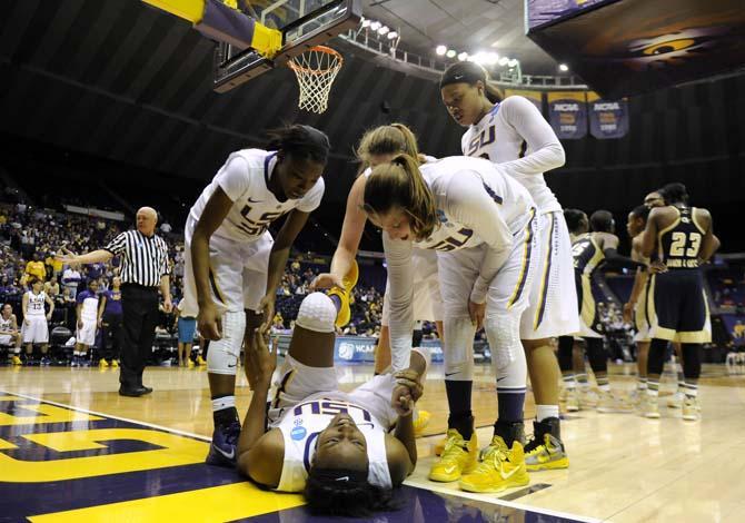 LSU senior forward Shanece McKinney (21) is surrounded by teammates after falling to the ground Sunday, March 23, 2014, during the Tigers' 98-78 victory against Georgia Tech in the PMAC.