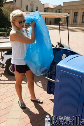 Climatology junior Courtney Mills empties a recycling bin Thursday as part of her student-worker duties for her job at LSU Recycling.