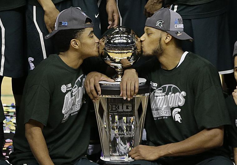 Michigan State's Gary Harris, left, and Adreian Payne kiss the championship trophy after they defeated Michigan 69-55 in an NCAA college basketball game in the championship of the Big Ten Conference tournament on Sunday, March 16, 2014, in Indianapolis. (AP Photo/AJ Mast)